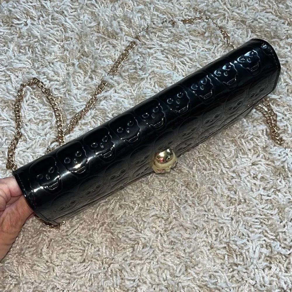 Awesome patent leather skull embossed clutch bag with gold chain shoulder strap.